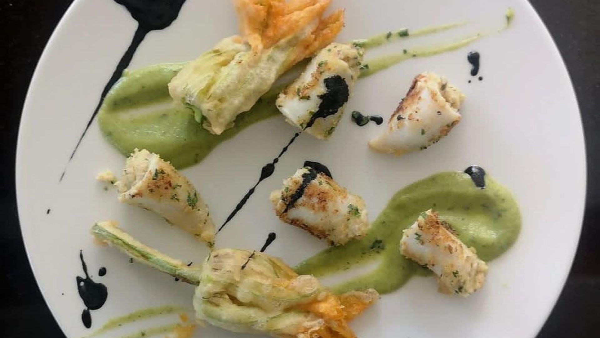 mangiare a Senigallia calamaretti ripieni guarniti con crema di zucchine coi suoi fiori in tempura